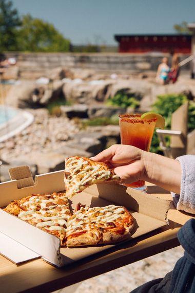 woman picking up a slice of pizza