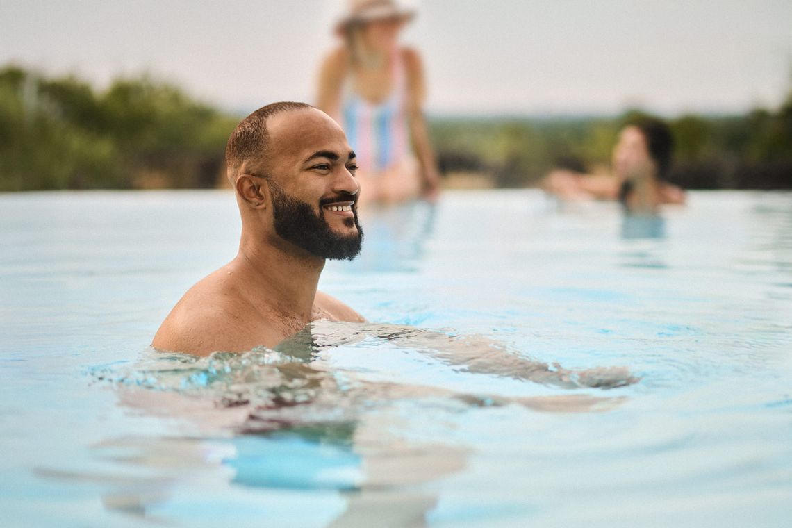 man relaxing in the infinity pool