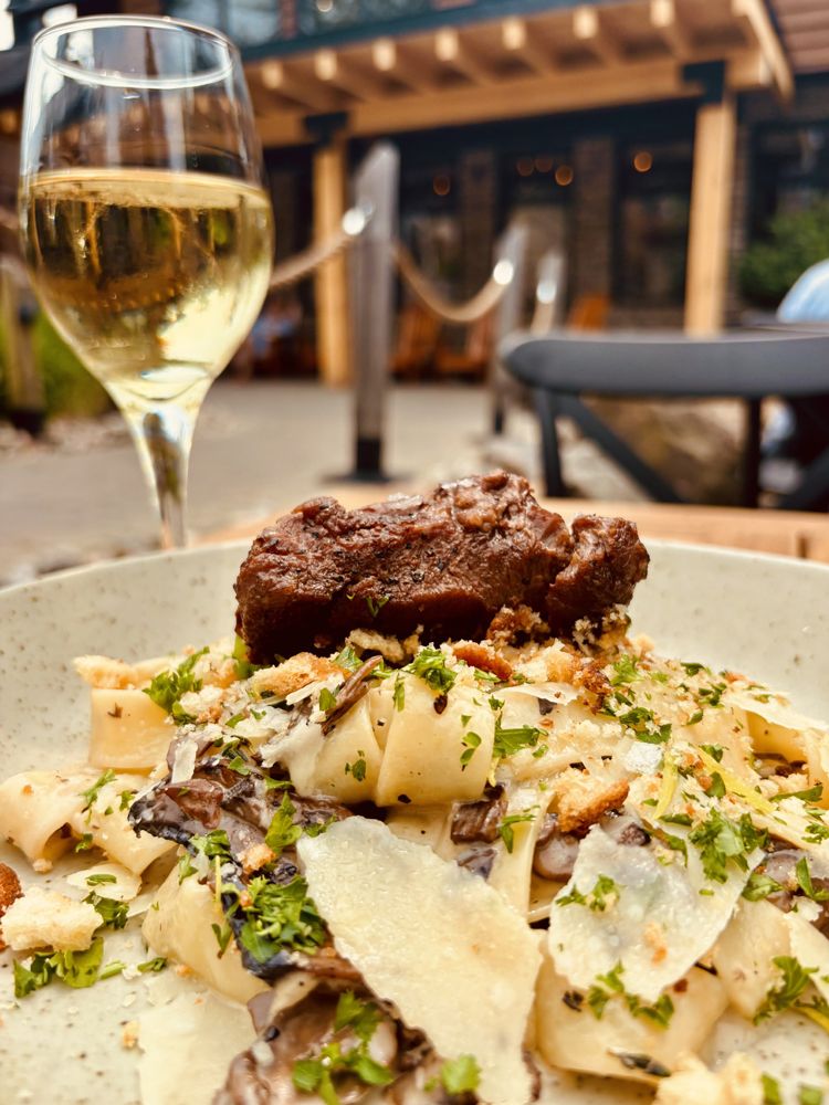 parpadelle pasta topped with a creamy, rich, and flavourful sauce and a braised beef cheek