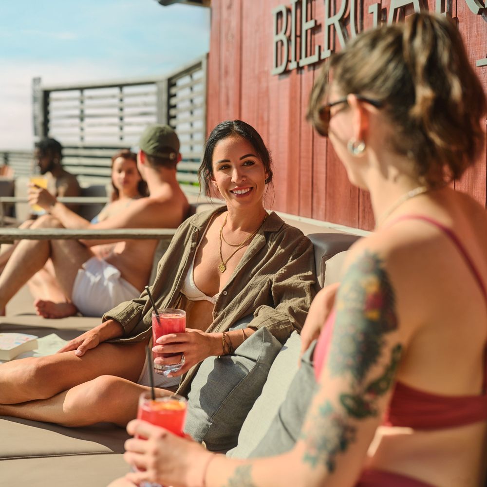 invités profitant du soleil, verre en main, au Biergarden