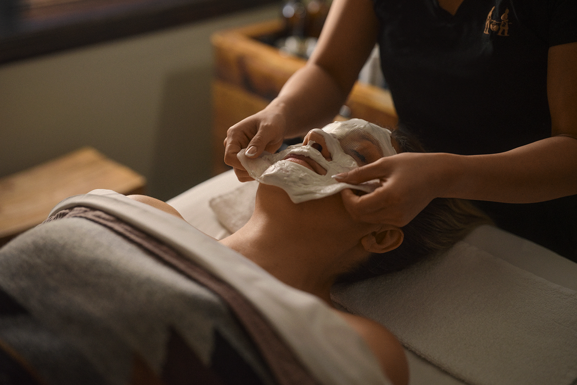 esthetician peeling off a face mask