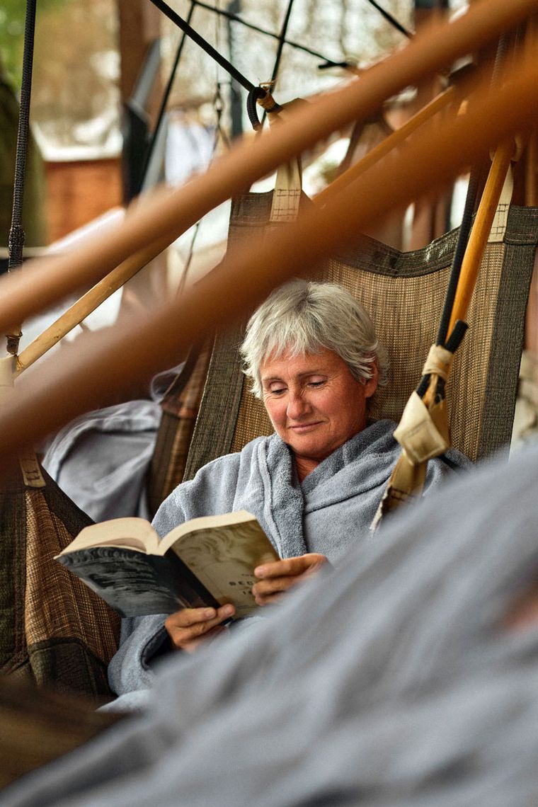 invité lisant un livre dans une chaise suspendue