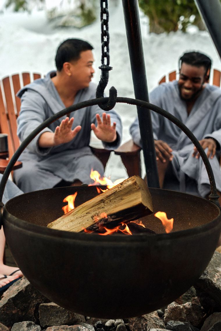 guests warming up by a fire cauldron