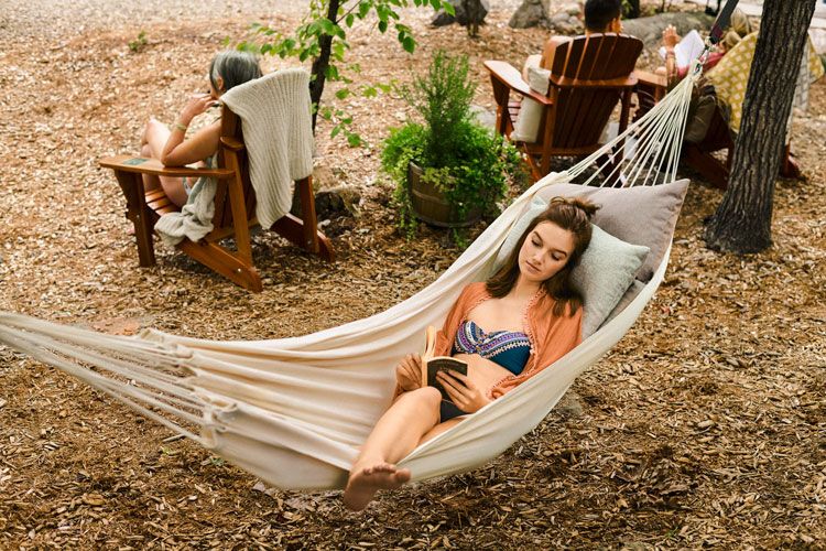 woman reading a book in a hammock