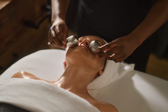 Esthetician using cryotherapy spoons on the guest's face