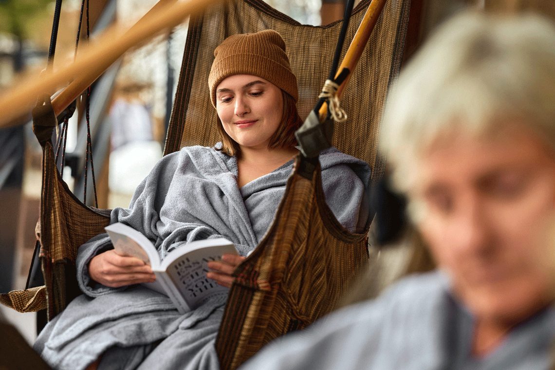 guest reading a book in a hanging chair