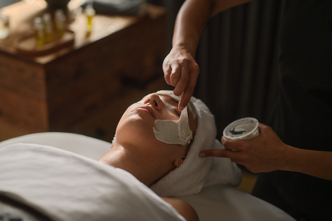 esthetician applying a face mask to a guest