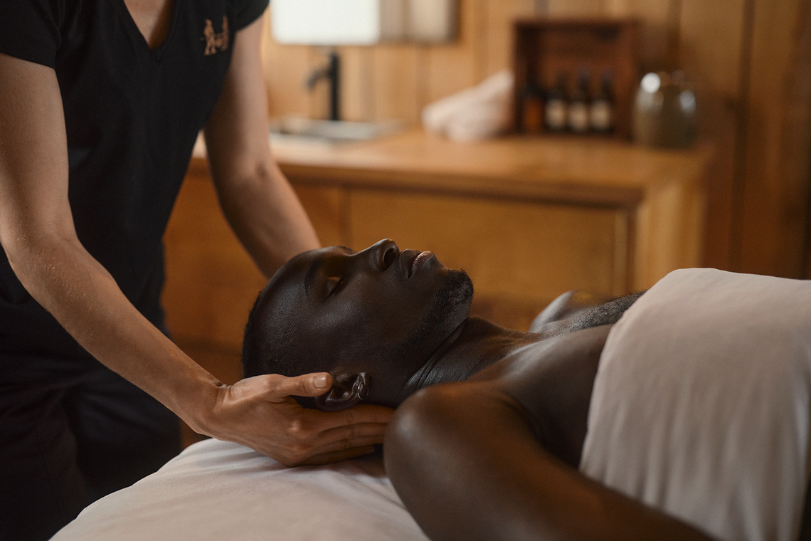 man enjoying a massage in an outdoor cabin