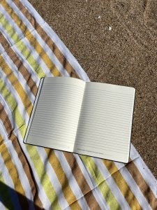 open journal on a towel on a beach