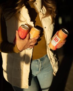 woman holding beer cans