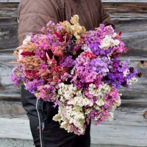 person holding a seasonal flowers bouquet