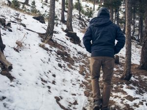 personne qui marche dans une forêt enneigée