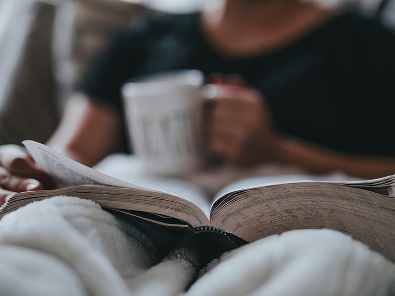 person reading a book in bed